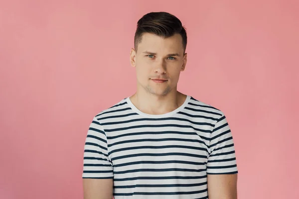 Frontansicht eines gutaussehenden Mannes im gestreiften T-Shirt, der isoliert auf rosa Kamera blickt — Stockfoto