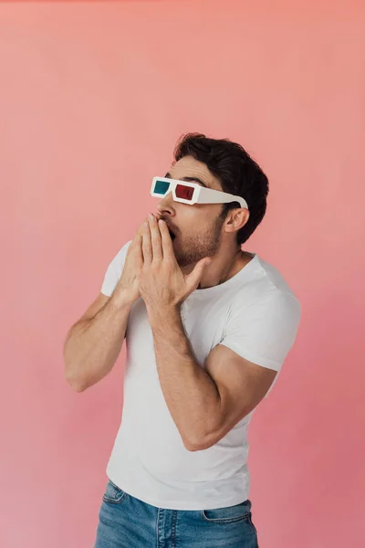 Homme musclé choqué dans des lunettes 3D couvrant la bouche avec les mains isolées sur rose — Photo de stock