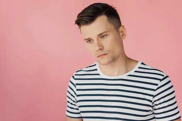 Pensive man in striped t-shirt looking away isolated on pink — Stock Photo
