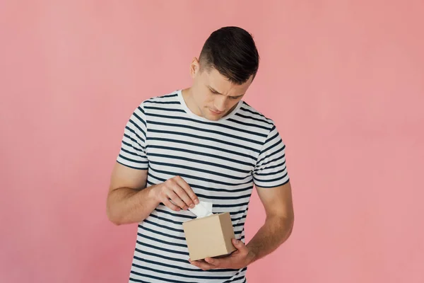 Man in striped t-shirt holding napkins isolated on pink — Stock Photo