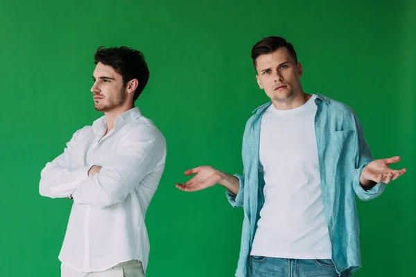 Двоє ображених чоловіків у сорочках ізольовані на зеленому — стокове фото