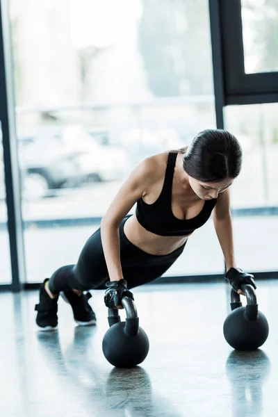 Mujer joven en ropa deportiva haciendo ejercicio con pesas - foto de stock