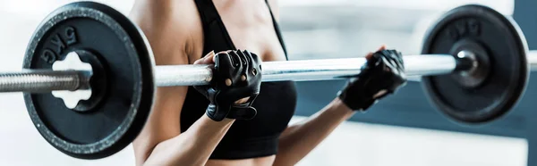 Панорамний знімок жінки, що працює з барбелом у спортзалі — стокове фото