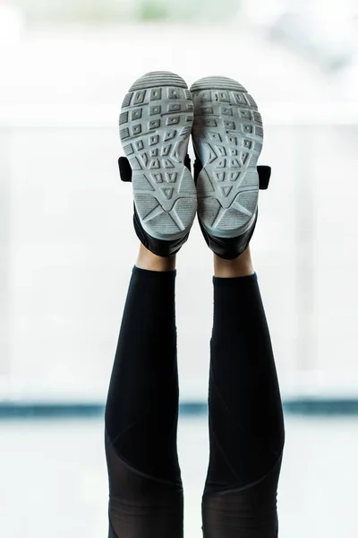 Vista ritagliata di gambe con scarpe da ginnastica di giovane donna — Foto stock
