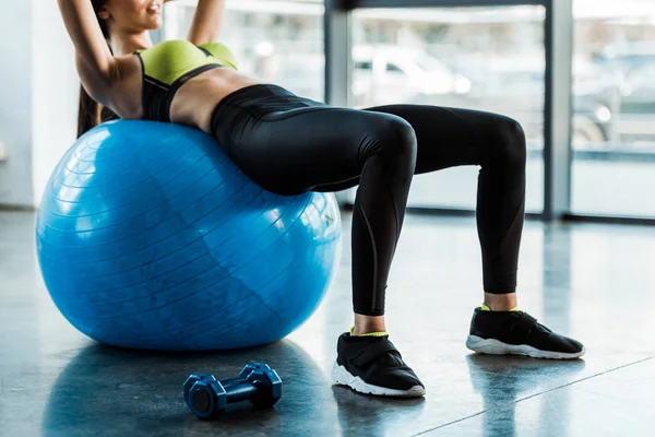 Обрезанный вид женщины, делающей упражнения на фитнес-мяч — стоковое фото