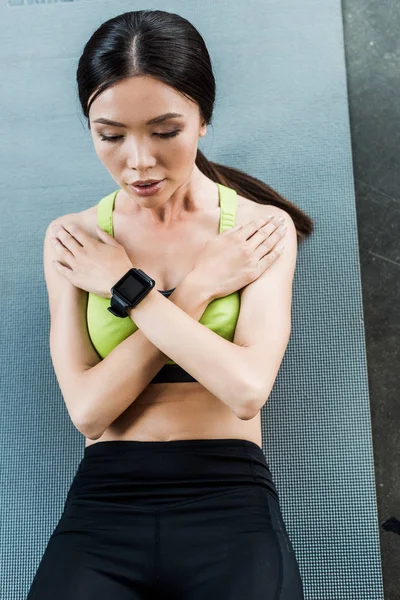 Visão aérea de menina atraente fazendo abdominais no tapete de fitness — Fotografia de Stock