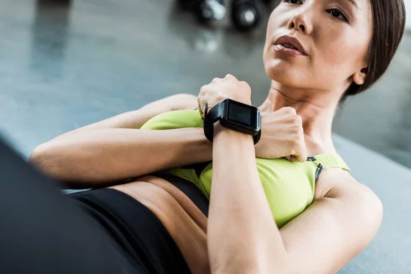 Cropped view of young woman doing do abs on fitness mat — Stock Photo