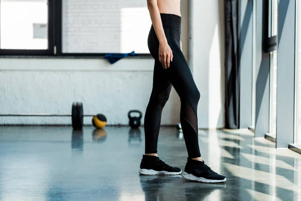 Cropped view of athletic girl standing in sports wear in gym — Stock Photo