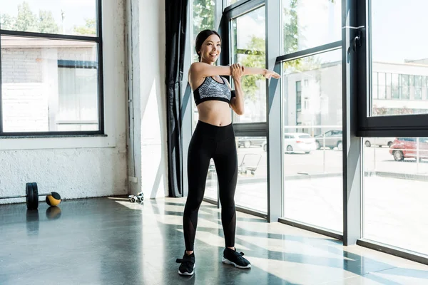 Happy athletic girl in sportswear exercising in sports center — Stock Photo