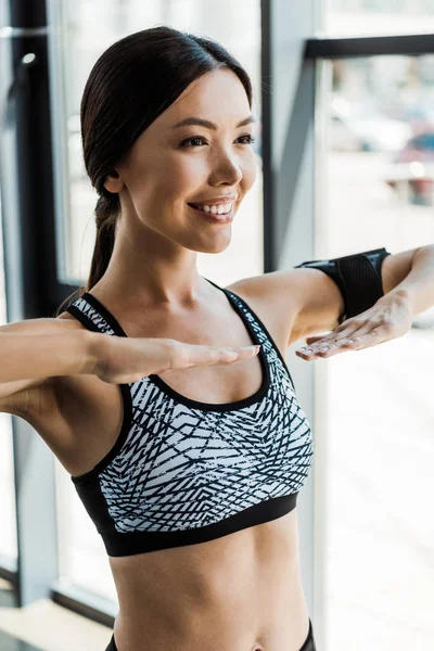 Cheerful young athletic woman working out in sports center — Stock Photo