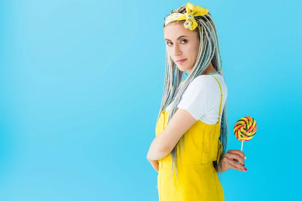 Girl with dreadlocks holding lollipop isolated on turquoise with copy space — Stock Photo