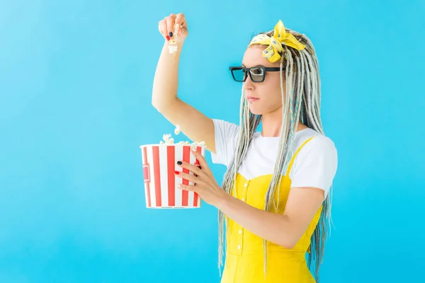 Дівчина з дредлоками в 3d окулярах тримає попкорн ізольовано на бірюзовому — стокове фото