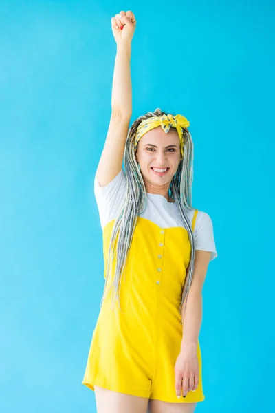 Chica con rastas animando con el puño cerrado aislado en turquesa - foto de stock