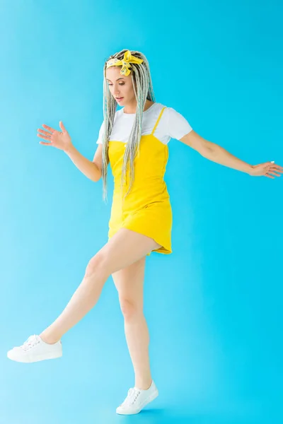 Girl with dreadlocks walking and gesturing on turquoise — Stock Photo