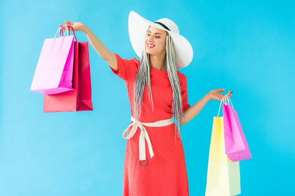 Hermosa chica de moda feliz con bolsas de compras aisladas en turquesa - foto de stock