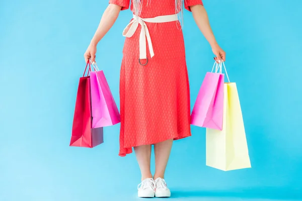 Vue recadrée de fille à la mode avec des sacs à provisions sur turquoise — Photo de stock