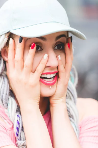 Bela menina sorridente com dreadlocks no chapéu olhando para longe — Fotografia de Stock