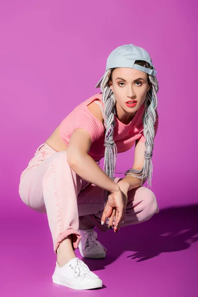 Bela menina elegante com dreadlocks em chapéu posando em roxo — Fotografia de Stock