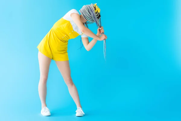 Девушка с дредами покрывает лицо с волосами на бирюзе с копировальным пространством — стоковое фото
