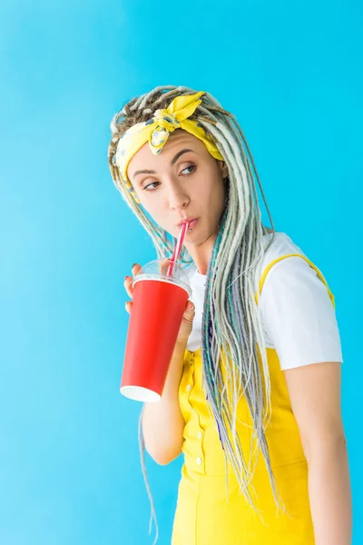 Menina bonita com dreadlocks beber refrigerante isolado em turquesa — Fotografia de Stock