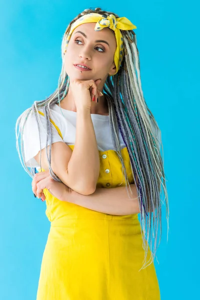 Thoughtful girl with dreadlocks propping chin with hand isolated on turquoise — Stock Photo