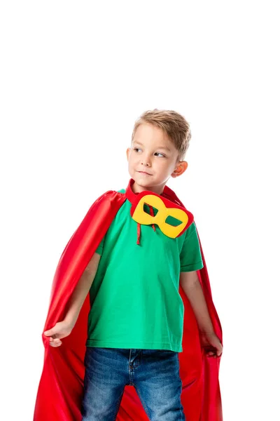 Enfant d'âge préscolaire en manteau de héros rouge et masque regardant loin isolé sur blanc — Photo de stock