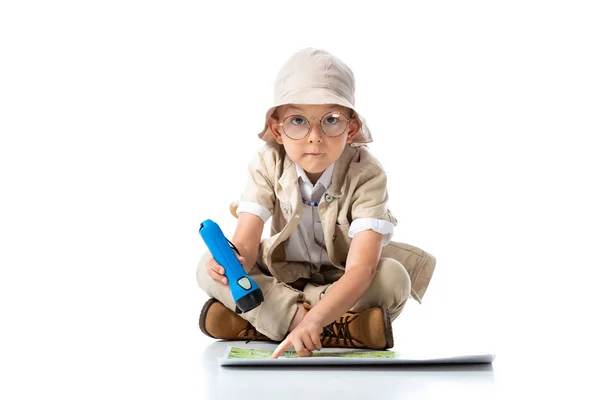 Исследователь ребенок в шляпе и очках держа фонарик и глядя на камеру на белом — стоковое фото