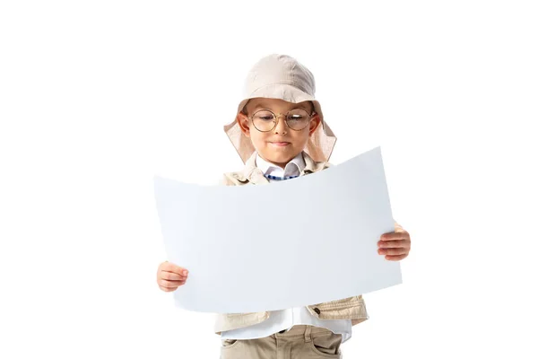 Niño explorador enfocado en gafas y sombrero mirando cartel aislado en blanco - foto de stock