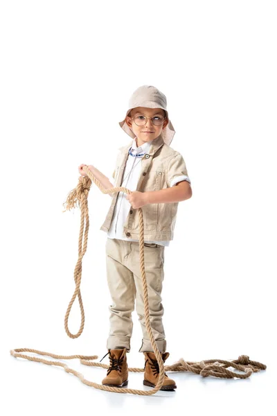 Vista completa del bambino esploratore in cappello e occhiali che tengono la corda sul bianco — Foto stock