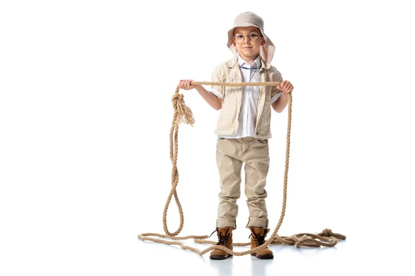 Vista completa del bambino esploratore in cappello e occhiali che tengono la corda sul bianco — Foto stock