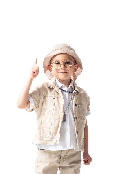 Vista frontal do menino explorador sorridente em óculos e chapéu olhando para a câmera e mostrando sinal ideia isolado no branco — Fotografia de Stock