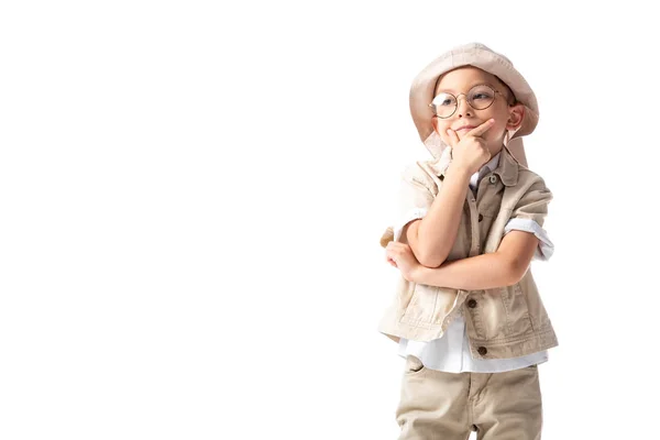 Nachdenklicher Entdeckerjunge mit Brille und Hut, der das Kinn berührt und isoliert auf Weiß wegschaut — Stockfoto