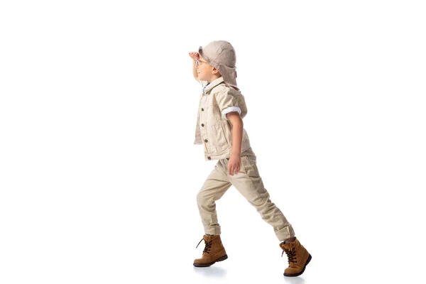 Full length view of explorer boy in hat and glasses looking in distance on white — Stock Photo