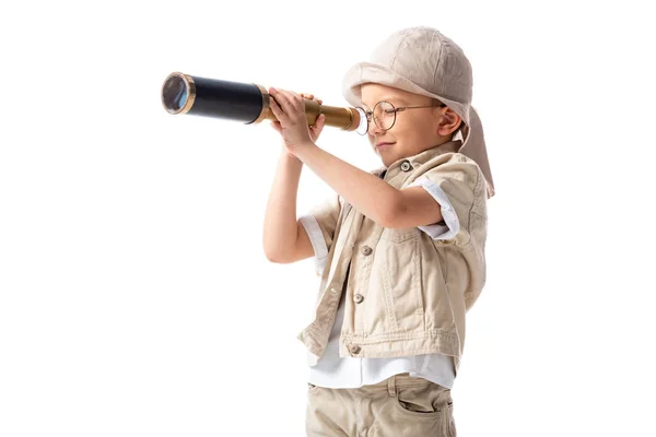 Explorer boy in glasses and hat looking through spyglass isolated on white — Stock Photo