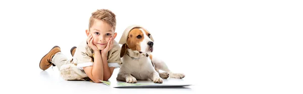 Plan panoramique de garçon souriant explorant et chien beagle chapeau près de la carte sur blanc — Photo de stock