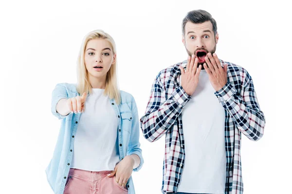 Дівчина вказує пальцем біля здивованого чоловіка, що прикриває рот ізольовано на білому — стокове фото