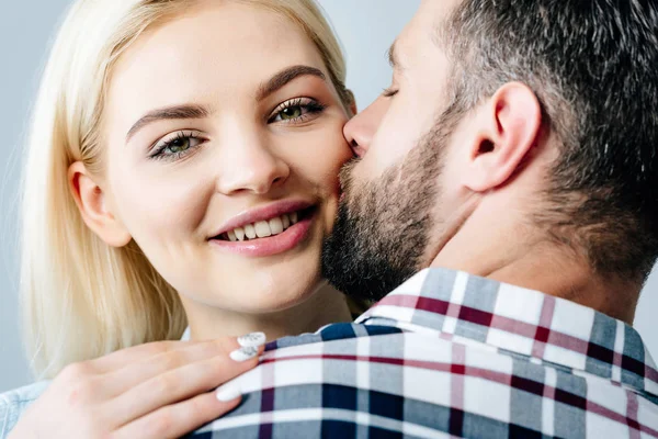 Uomo e felice giovane donna baciare isolato su grigio — Foto stock