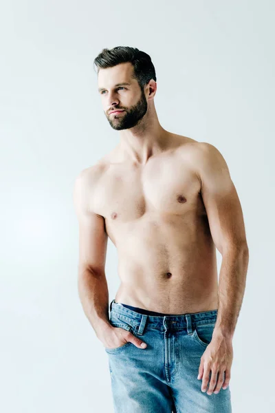 Hemdlos schöner Mann in Jeans posiert mit der Hand in der Tasche auf grau — Stockfoto