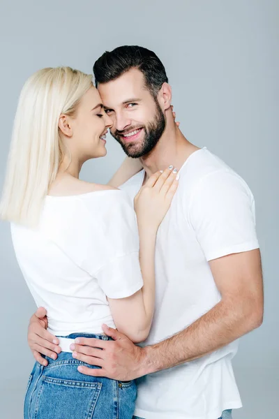 Belo feliz jovem casal abraçando e sorrindo isolado no cinza — Fotografia de Stock