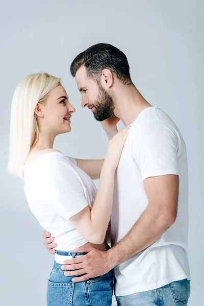 Belo feliz jovem casal abraçando e sorrindo isolado no cinza — Fotografia de Stock