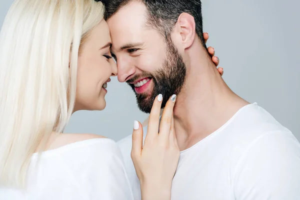 Hermosa chica feliz abrazando hombre aislado en gris - foto de stock