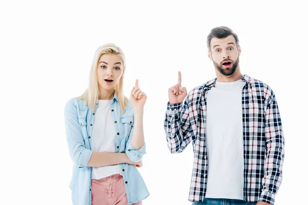 Шокована дівчина і чоловік вказують пальцями вгору ізольовані на білому — Stock Photo