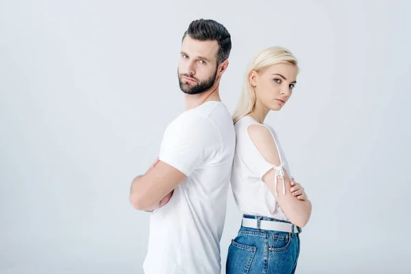 Man and young woman standing back to back with crossed arms isolated on grey — Stock Photo