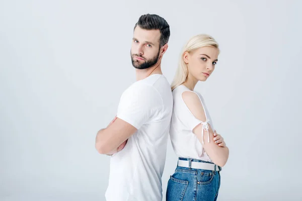 Hombre y mujer joven de pie espalda con los brazos cruzados aislados en gris - foto de stock