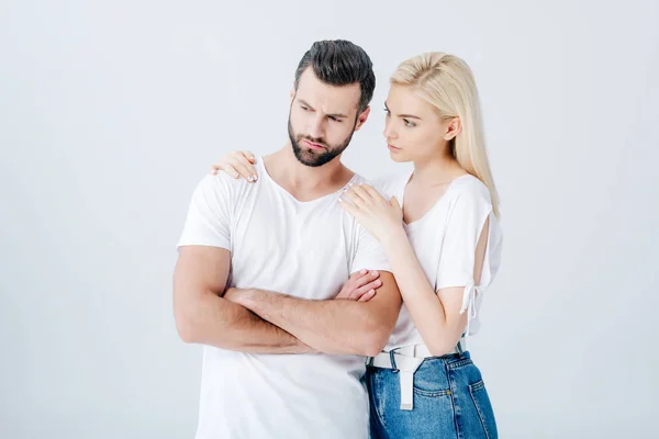 Young woman embracing upset man isolated on grey — Stock Photo