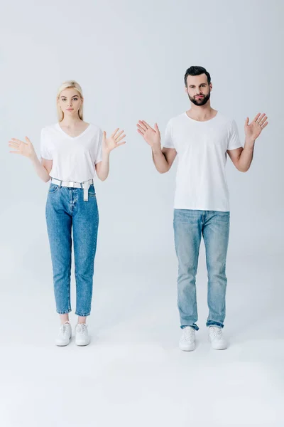 Man and young woman posing with open palms isolated on grey — Stock Photo