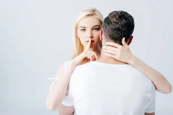 Schönes Mädchen umarmt Mann und tut Schweigegegeste isoliert auf grau — Stockfoto