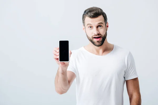 Uomo scioccato mostrando smartphone con schermo bianco isolato sul grigio — Foto stock