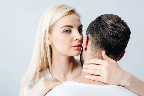 Beautiful girl looking at camera and embracing man isolated on grey — Stock Photo