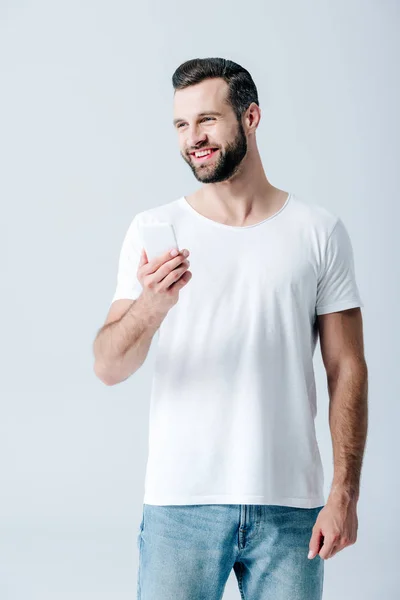 Happy handsome man using smartphone isolated on grey — Stock Photo